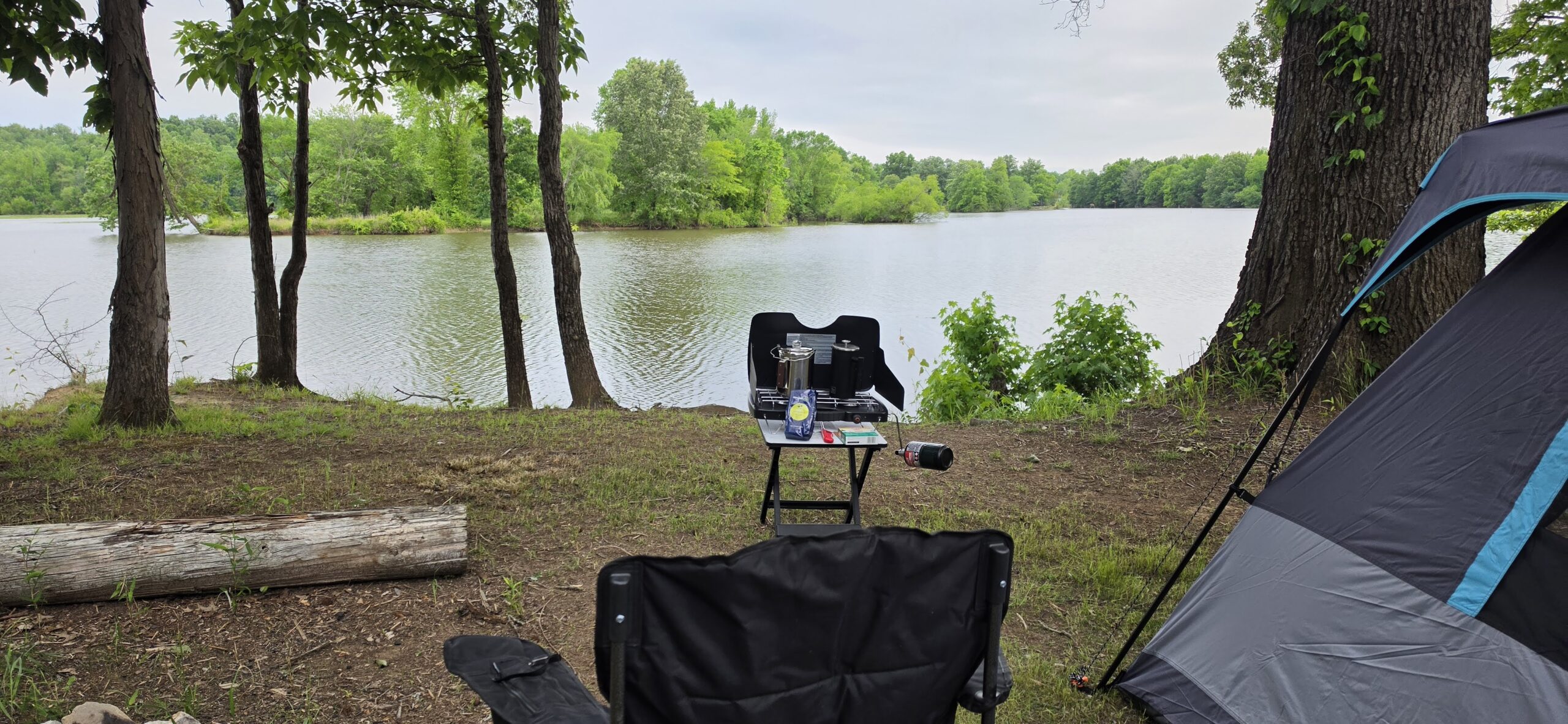 Camp pitched on the Tennessee River bank at Blue Heron, chair and cook stove facing the water