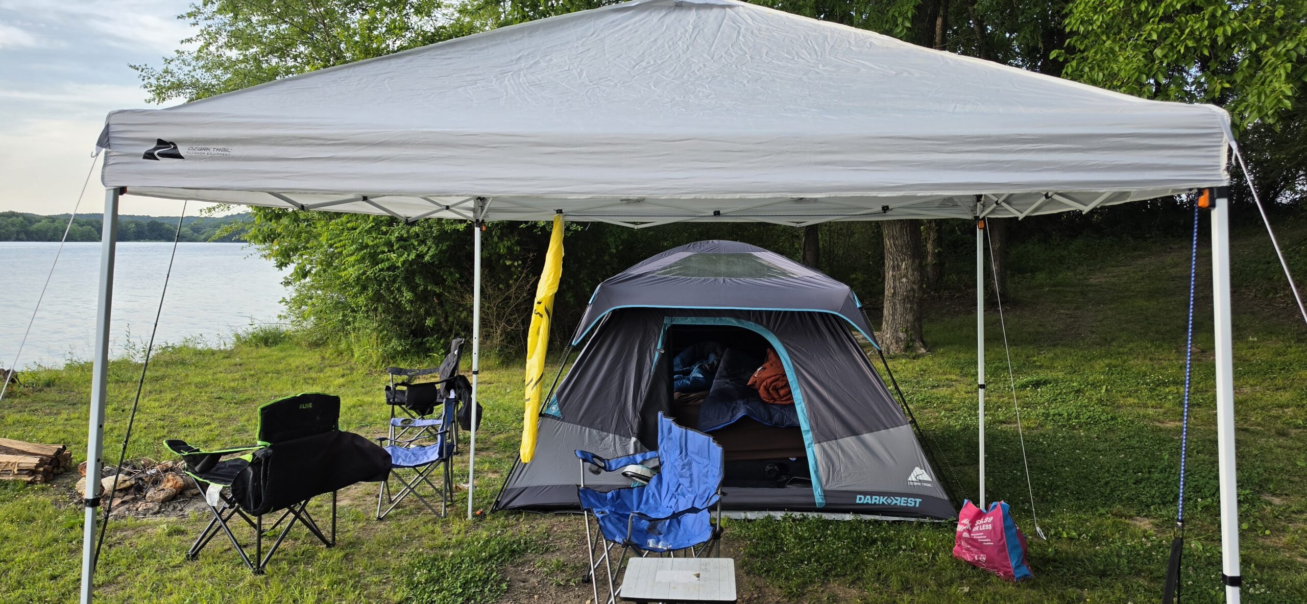 Tent set up under a canopy at a riverside campsite, Blue Heron Campground